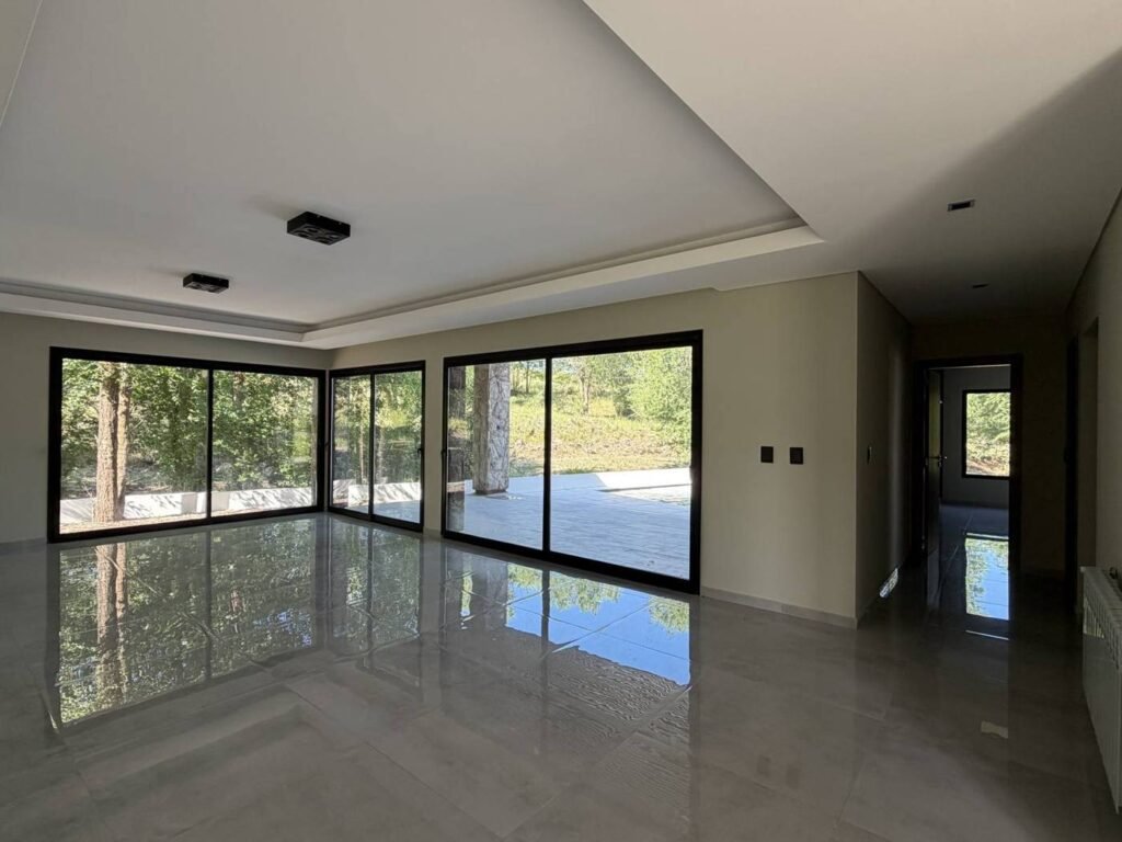 Casa A30 en Altos de Carlos Paz: living con aberturas al parque