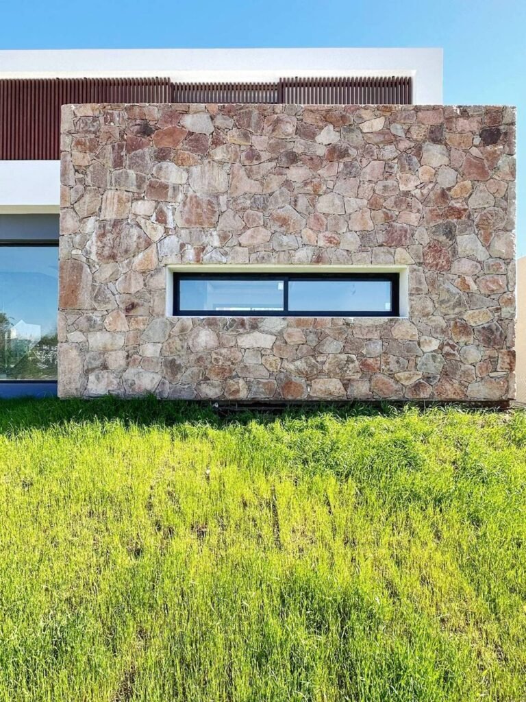 Casa A9 en Altos de Carlos Paz: muro de piedra