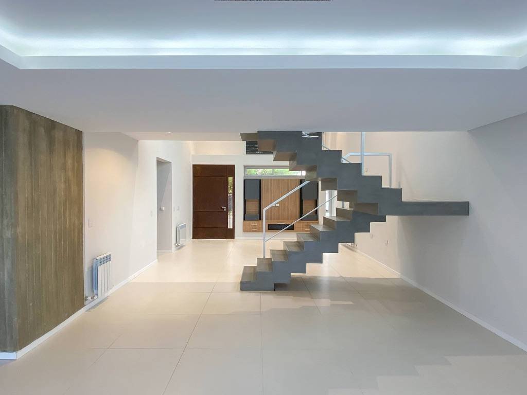Casa Alem en Villa Carlos Paz: living en doble altura con escalera
